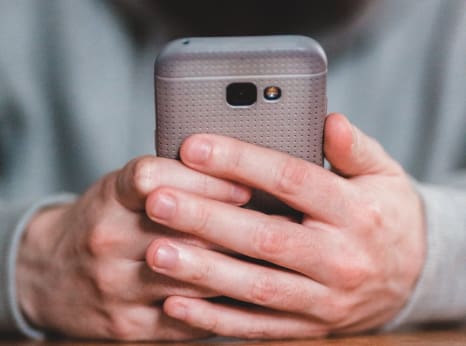 Close-up of a hand holding a smartphone, symbolizing easy access to resources.