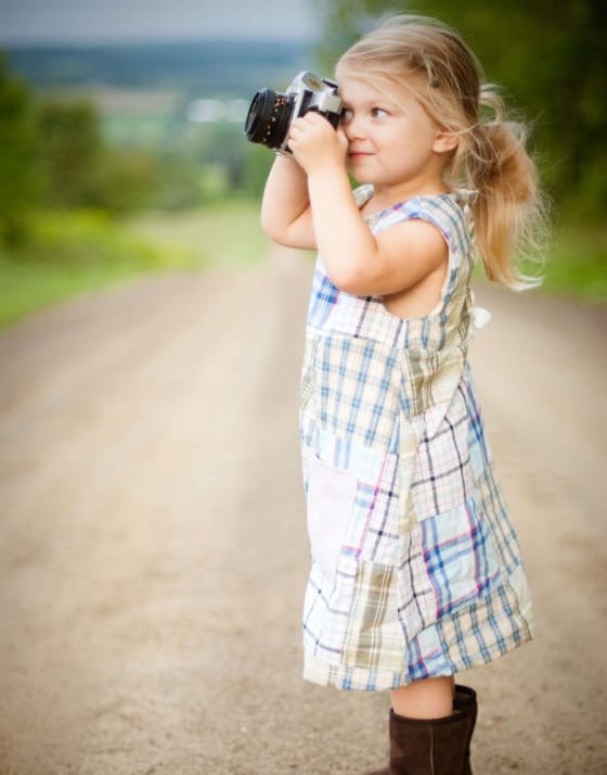 Young girl looking through binoculars, symbolizing future vision and hope for caregivers.